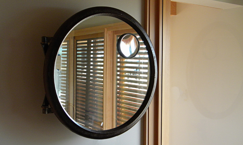 Ruby Fold extendable vanity mirror made of reclaimed truck rim and recycled steel.
