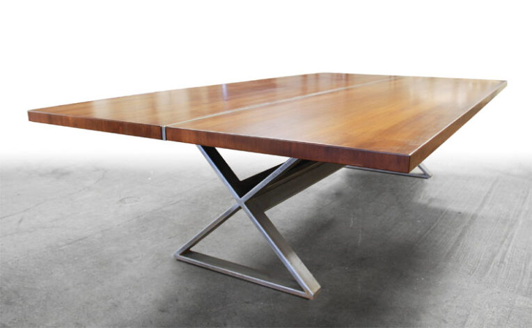 The Ruby Mahongany Dining Table has a classic "X" style steel base.