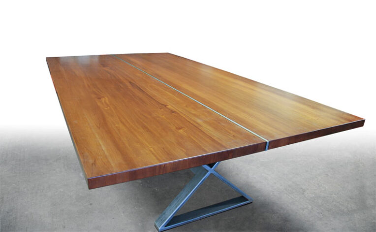 The Ruby Mahongany Dining Table has a classic "X" style steel base.