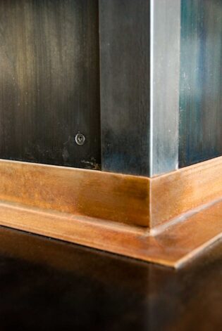 The "19th" Fireplace Surround is a tower of hand crafted decorative patina'd steel panels, C-Channel and rivets.