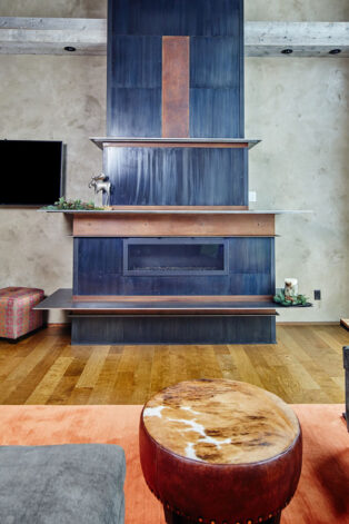The "19th" Fireplace Surround is a tower of hand crafted decorative patina'd steel panels, C-Channel and rivets.