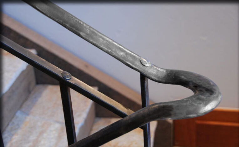"Snake River" Stair Railing hand forged and hammered, with hand hammered pegs.