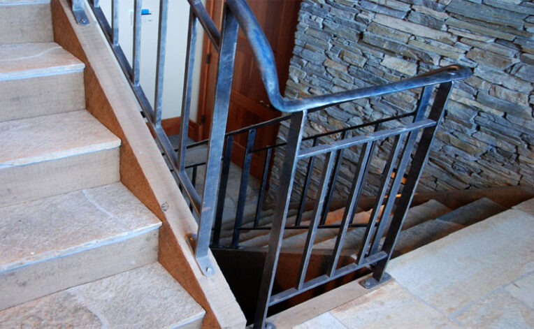 "Snake River" Stair Railing hand forged and hammered, with hand hammered pegs.