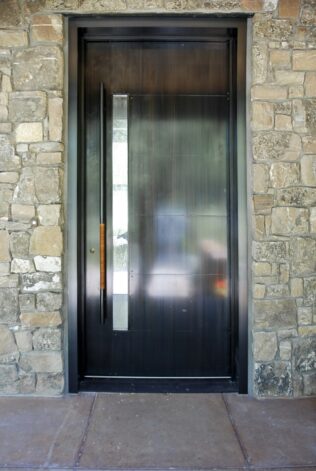 Rockcress Door made with Cherry Wood on the inside and hand patina'd steel on the outside with a hand woven leather pull.