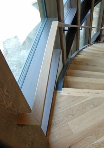 Brandner Design "Floating Stair" built in a radius with White Oak treads and supported by cables hung from upstairs railing.