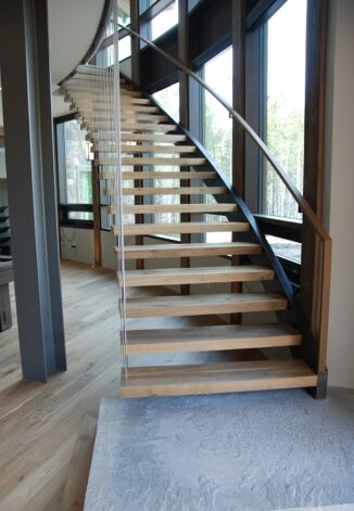 Brandner Design "Floating Stair" built in a radius with White Oak treads and supported by cables hung from upstairs railing.