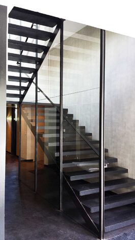 Brandner Design "Hilltop Modern" Stairs made with minimal steel supports, Black stained White Oak treads with open risers and large glass panels.