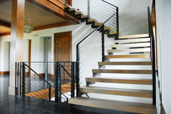 Brandner Design's "Hunterdon Stair" built on a floating steel stringer with Grey Washed White Oak treads and patina'd cables.