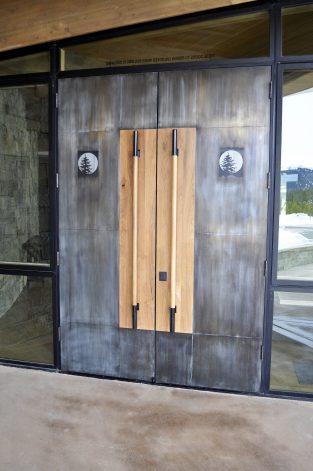 Modern custom doors for Moonlight Basin Big Sky MT. Made of blackened steel, Bleached Walnut handles and laser etched images.