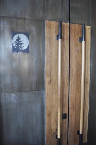 Modern custom doors for Moonlight Basin Big Sky MT. Made of blackened steel, Bleached Walnut handles and laser etched images.