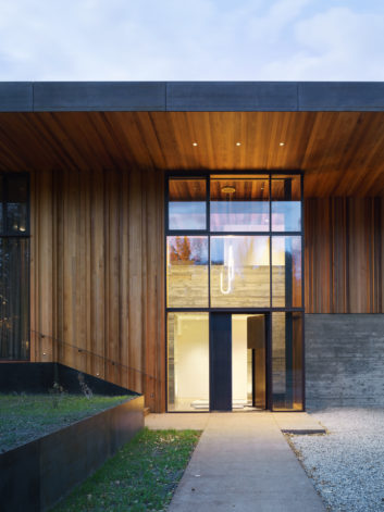 Riverbend Residence -modern industrial door & blackened Steel Siding cladding