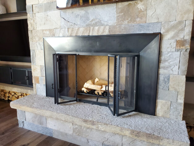 Eagle View Fireplace with bi-fold glass doors and steel fire screen curtain.