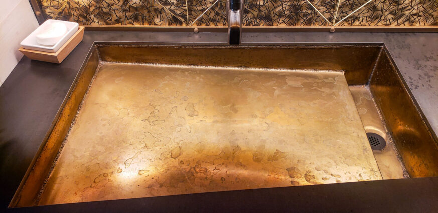 Golden brass sink and hand hammered brass backsplash by Brandner Design