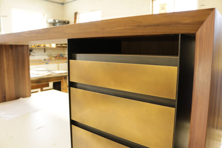 The Recessed Shadow Desk with walnut desktop steel and brass drawers.