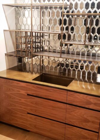 Hexagonal etched-mirror with integrated lighting on walnut Wet Bar at Ross Peak Residency.