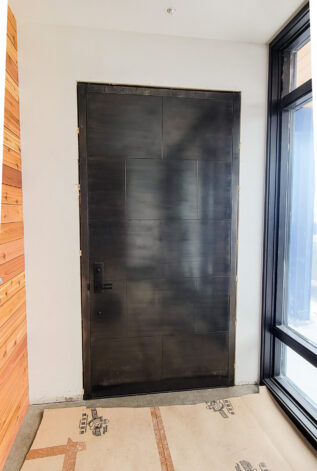 Custom front door with Blackened Stainless Steel Glued Panels by Brandner Design