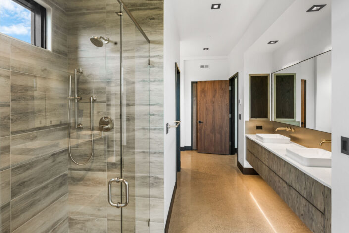 Sales Place Residence bathroom with grain-matched veneer cabinets and stainless steel backsplash
