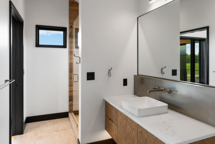 Sales Place Residence bathroom with stainless steel backsplash and waknut veneer cabinets with sedan pulls