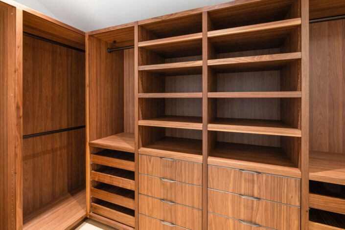 Sales Place walk-in closet with walnut veneer cabinets and sedan pulls